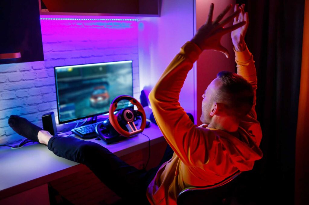 male-gamer-playing-racing-games-computer-he-uses-steering-wheel-emotional-game